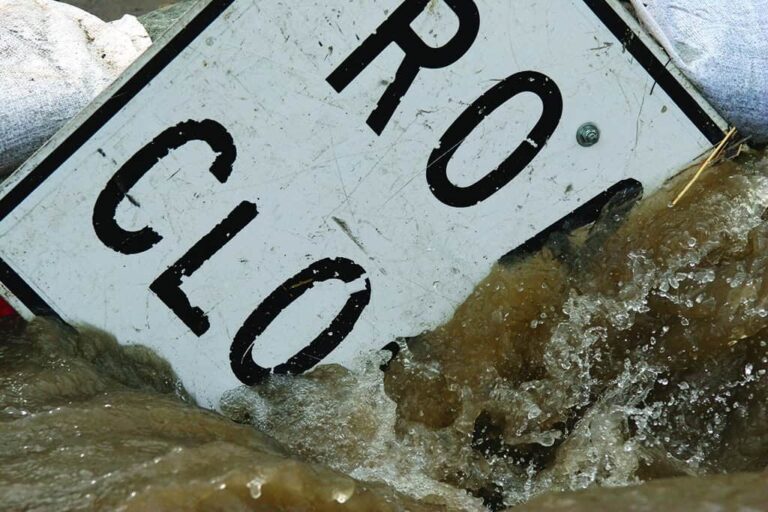 road closed sign under raging water